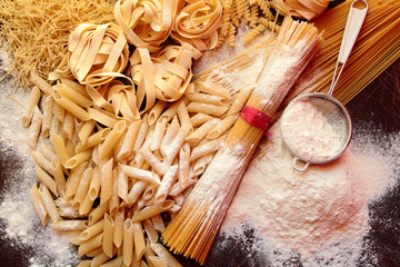 Fototapeta na wymiar Variety of types and shapes of pasta with white flour