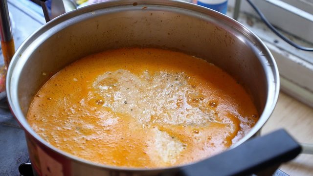 Stirring with Blender Tomato Carrot Cream Soup in Pan.