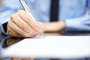 Business man signing the contract to finalize a deal