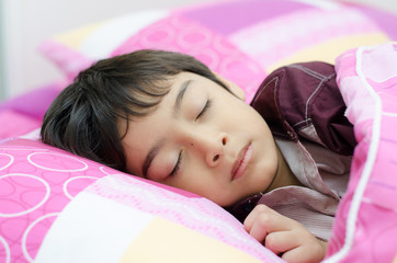 Obraz na płótnie Canvas Little boy sleeping in bed on white background