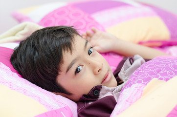 Little boy sleeping in bed on white background