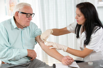 Nurse with syringe is taking blood for test at the doctor office