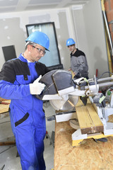 Construction worker using electric saw