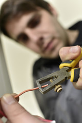 Electrician cutting wire to prepare installation