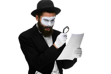 Man with a face mime reading through magnifying glass