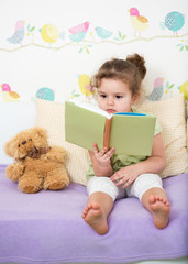 kid girl reading story for teddy bear