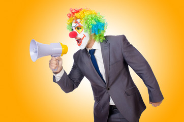 Businessman clown with loudspeaker on white