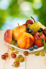 different fruits on green background
