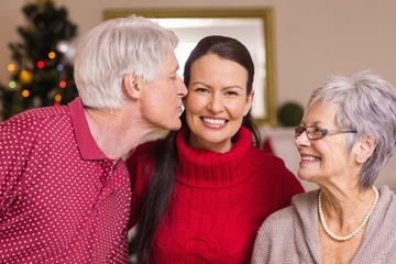 Grandfather kissing the mother at christmas