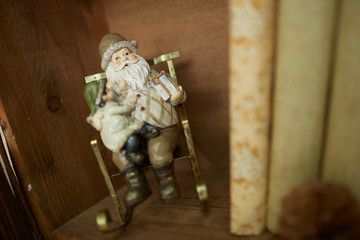 Toy Santa with a gnome in a rocking chair on the shelf