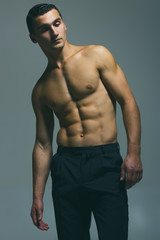 Fototapeta premium Male beauty concept. Fashionable and undressed young man in blac