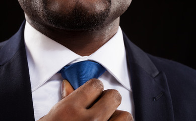 Businessman adjusting his necktie