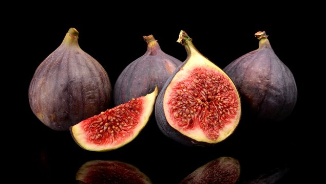 Group sliced figs isolated on black background