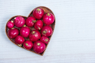 heart shape with fresh radish on white table