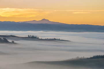 Fantastic Tuscan landscape in the fog and the light of the risin