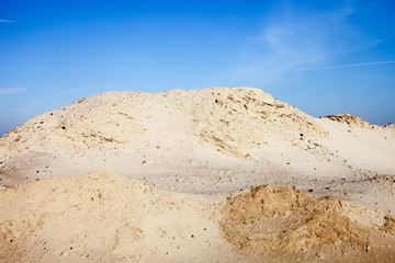 Fototapeta na wymiar Pile of sand and blue sky over it