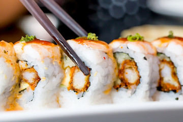 Sushi roll with black chopsticks