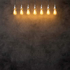 Decorative vintage lightbulbs on dark concrete background