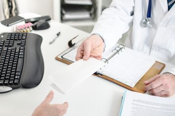 Doctor giving a prescription to his patient