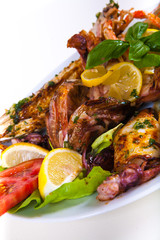 Grilled fish with vegetables on plate. Isolated on a white
