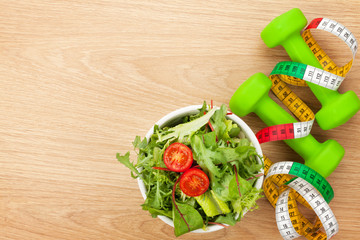 Dumbells, tape measure and healthy food. Fitness and health