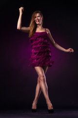 Naklejka premium Beautiful woman in purple dress dancing