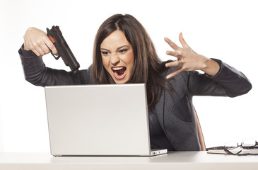 angry businesswoman wants to shoot at her laptop with a gun