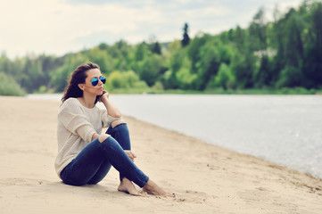 Sexy young woman sitting on a beach outdoor fashion portrait