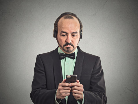 man listening to music on smartphone with pair of headphones