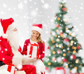smiling little girl with santa claus and gifts
