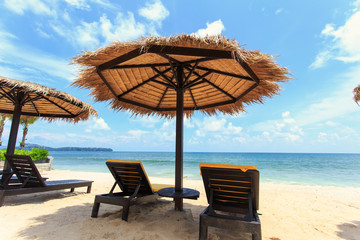 Sun umbrella and sun loungers stand at the beach in Phuket, Thai