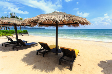 Sun umbrella and sun loungers stand at the beach in Phuket, Thai