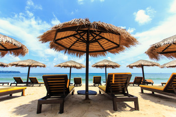 Sun umbrella and sun loungers stand at the beach in Phuket, Thai