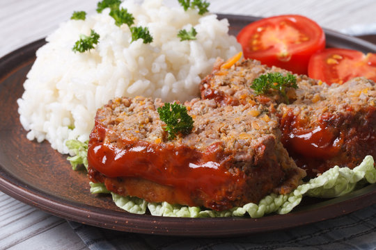 meatloaf with rice and tomatoes on a plate close-up