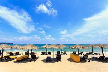Sun umbrella and sun loungers stand at the beach in Phuket, Thai