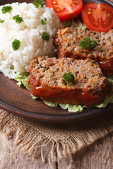 meatloaf with rice and vegetables on a plate closeup, vertical