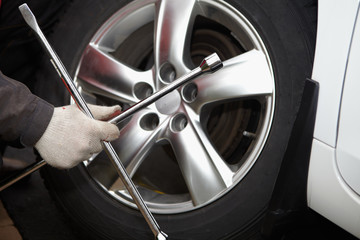 Car mechanic changing tire.