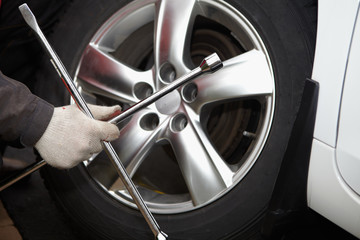Fototapeta premium Car mechanic changing tire.
