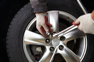 Car mechanic changing tire.