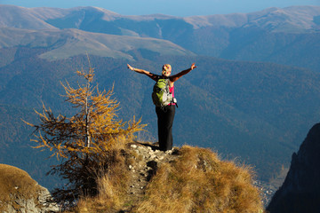 Women with open arms ready to jump with parachute, on mountain