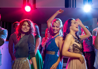 smiling friends dancing in club