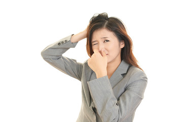 鼻をおさえる女性