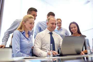 smiling business people with laptop in office