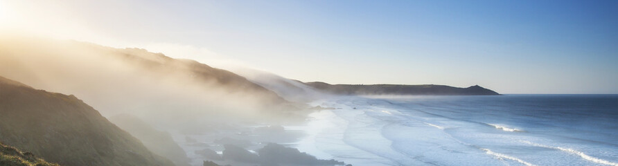 Amazing panorama of headland and sea fog at sunrise.