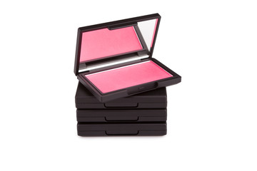 Pink blush on a pile of blush boxes isolated on white