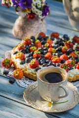 Fruit tart served with coffee in the summer garden