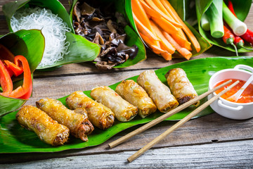 Fried spring rolls surrounded by ingredients - obrazy, fototapety, plakaty