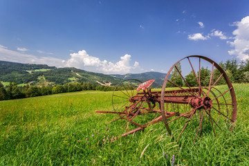 Red rake in a field in the mountains