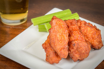 Chicken Buffalo Wings with Celery Sticks and Beer