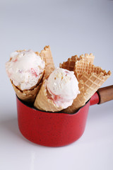ice cream cone in a red metal pot on white background
